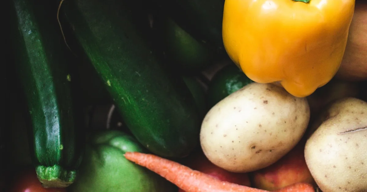 Pilha de legumes frescos variados com folhas e talos visíveis