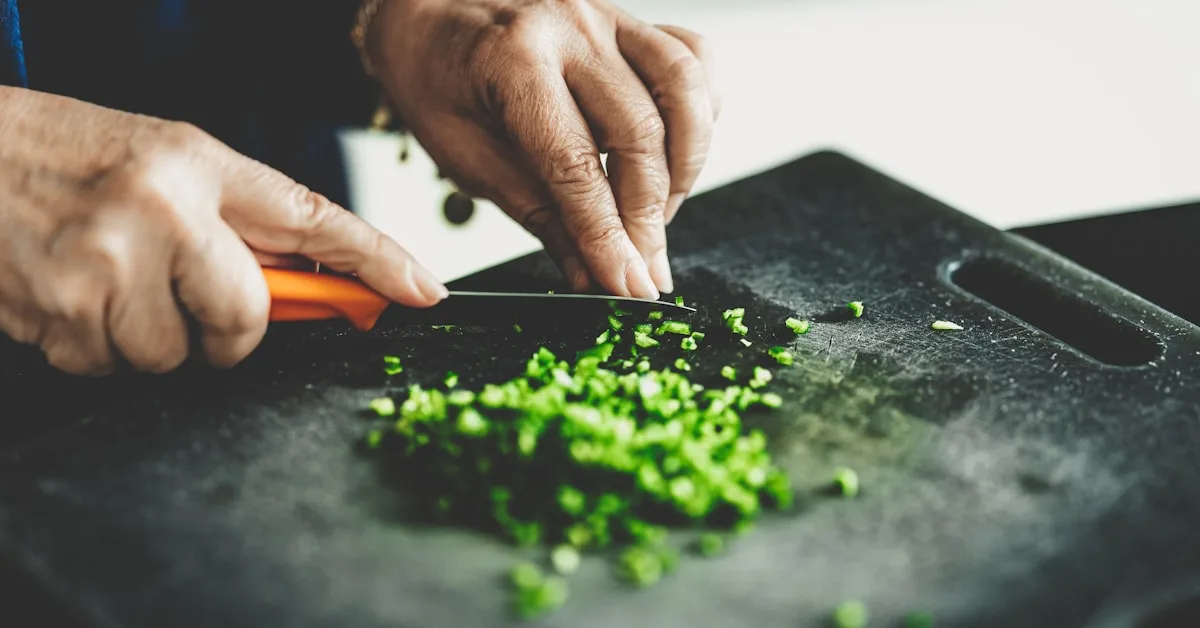 Verduras coloridas sendo fatiadas em uma tábua de corte de madeira na cozinha